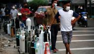 People wearing protective masks queue to refill oxygen tanks as Indonesia experiences an oxygen supply shortage amid a surge of coronavirus disease (COVID-19) cases, at a filling station in Jakarta, Indonesia, July 5, 2021. REUTERS/Willy Kurniawan/File Ph