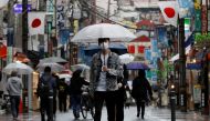 A man wearing a protective face mask, amid the coronavirus disease (COVID-19) pandemic, makes his way at a local shopping street in Tokyo, Japan, May 5, 2021. REUTERS/Kim Kyung-Hoon/File Photo