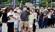 People wait in line for a coronavirus disease (COVID-19) test at a testing site which is temporarily set up at a railway station in Seoul, South Korea, July 7, 2021. REUTERS/ Heo Ran