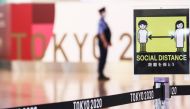 A social distancing sign is seen in front of a police officer before the arrival of International Olympic Committee (IOC) President Thomas Bach at Haneda Airport ahead of Tokyo 2020 Olympic Games, in Tokyo, Japan July 8, 2021. REUTERS/Kim Kyung-Hoon