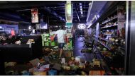A self-armed local looks for looters inside a supermarket following protests that have widened into looting, in Durban, South Africa July 13, 2021, in this screen grab taken from a video. Courtesy Kierran Allen/via REUTERS 