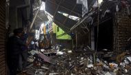 People use their mobile phones to take pictures of a collapsed building following rains in Mumbai, India, July 23, 2021. REUTERS/Stringer 