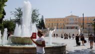 People make their way to Syntagma square during a heatwave in Athens, Greece, August 2, 2021. REUTERS/Costas Baltas