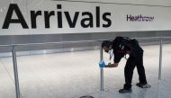 A worker sanitises a barrier at the International arrivals area of Terminal 5 in London's Heathrow Airport, Britain, August 2, 2021. REUTERS/Peter Nicholls
