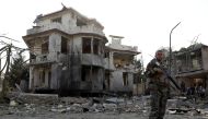 An Afghan National Army (ANA) soldier keeps watch at the site of yesterday's night-time car bomb blast in Kabul, Afghanistan August 4, 2021. REUTERS/Stringer