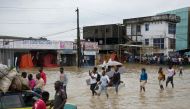 People make their way through a flooded street after the heavy rains in Douala, Cameroon, August 12, 2021. REUTERS/Joel Kouam