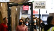 People queue to receive a dose of the Pfizer BioNTech vaccine at an NHS vaccination centre hosted at the Heaven nightclub, amid the coronavirus disease (COVID-19) pandemic, in London, Britain, August 8, 2021. REUTERS/Henry Nicholls

