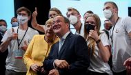 Prime Minister of North Rhine-Westphalia and candidate for chancellor of the CDU/CSU Armin Laschet and German Chancellor Angela Merkel pose for a selfie with participants during a CDU/CSU campaign kick off ahead of the federal election at Tempodrom in Ber