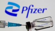FILE PHOTO: Syringe and vial are seen in front of displayed new Pfizer logo in this illustration taken, June 24, 2021. REUTERS/Dado Ruvic/Illustration