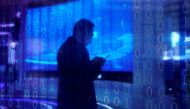 A man looking at a phone is seen through a digitally decorated glass during the World Internet Conference (WIC) in Wuzhen, Zhejiang province, China, November 23, 2020. REUTERS/Aly Song/File Photo