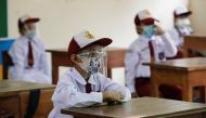 Elementary school students wearing face masks and face shields attend class, as schools reopen on trial basis after the government extended restrictions to curb the spread of coronavirus disease (COVID-19) in Jakarta, Indonesia, August 30, 2021. REUTERS/A