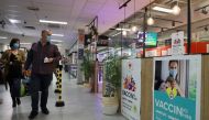 Shoppers, wearing protective face masks, walk past posters for a coronavirus disease (COVID-19) vaccination centre installed inside a supermarket in Brussels, Belgium, August 30, 2021. REUTERS/Bart Biesemans
