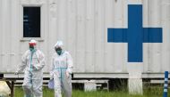 Health workers in hazmat suits walk outside the Manila COVID-19 Field Hospital in Manila, Philippines, September 7, 2021. REUTERS/Lisa Marie David