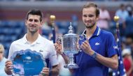 (L-R) Novak Djokovic of Serbia and Daniil Medvedev of Russia celebrate with the finalist and championship trophies, respectively, after their match in the men's singles final on day fourteen of the 2021 U.S. Open tennis tournament at USTA Billie Jean King
