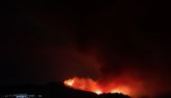 A wildfire is seen from a balcony near the town of Pujerra, which was evacuated, in Cartajima, near Estepona, Spain, September 12, 2021. REUTERS/Jon Nazca