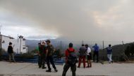 Residents watch a wildfire on Sierra Bermeja mountain after they made a firewall in Benarraba, near Estepona, Spain, September 13, 2021. Reuters/Jon Nazca