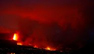 Lava flows behind houses following the eruption of a volcano in the Cumbre Vieja national park, in this picture taken from Tazacorte, on the Canary Island of La Palma, Spain September 20, 2021. REUTERS/Borja Suarez