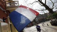 A woman walks past a national flag, the day before a general election, in Delft, Netherlands, March 14, 2017. REUTERS/Yves Herma