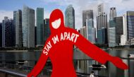 A man wearing a face mask passes a sign put up to encourage social distancing during the coronavirus disease (COVID-19) outbreak, at Marina Bay in Singapore, September 22, 2021. Reuters/Edgar Su/File Photo