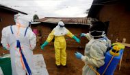 Kavota Mugisha Robert, a healthcare worker, who volunteered in the Ebola response, decontaminates his colleague after he entered the house of 85-year-old woman, suspected of dying of Ebola, in the eastern Congolese town of Beni in the Democratic Republic 