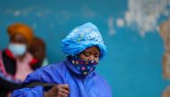 A woman wearing a protective face mask against the coronavirus disease (COVID-19) and a plastic bag on her head to protect from the rain looks on, as the new Omicron coronavirus variant spreads, at Tsomo, a town in the Eastern Cape province of South Africa, December 2, 2021. Picture taken December 2, 2021. REUTERS/Siphiwe Sibeko