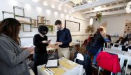 People have their coronavirus disease (COVID-19) health passes, known as Green Passes, checked at a restaurant, on the day before health passes become mandatory on public transport, in Rome, Italy December 5, 2021. REUTERS/Remo Casilli
