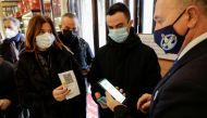 Customers have their coronavirus disease (COVID-19) health pass, known as a Green Pass, checked as they arrive at a bar the day the government restricts access of unvaccinated to indoor venues, in Naples, Italy December 6, 2021. REUTERS/Ciro de Luca