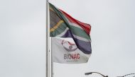 FILE PHOTO: A South African flag flies beside a flag bearing the logo of the local vaccine manufacturing and storage company Biovac, outside the company's offices in Cape Town, South Africa, March 18, 2021. REUTERS/Mike Hutchings/File Photo
