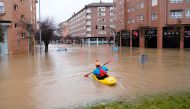 A man rides a kayak on a flooded road, following heavy rainfall in Pamplona, Spain, December 10, 2021. REUTERS/Vincent West