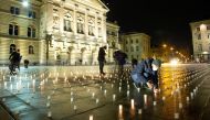 Volunteers light some of more than 11,000 candles, one for each victim of the coronavirus disease (COVID-19) pandemic in Switzerland, during a candlelight vigil in front of the seat of the Swiss federal parliament Bundeshaus in Bern, Switzerland December 7, 2021. Picture taken December 7, 2021. REUTERS/Arnd Wiegmann/File Photo