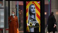 People walk past a government health campaign advertisement encouraging people to take a coronavirus disease (COVID-19) vaccine booster dose, at a bus stop in London, Britain, December 17, 2021. Reuters/Toby Melville