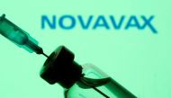 FILE PHOTO: A vial and sryinge are seen in front of a displayed Novavax logo in this illustration taken January 11, 2021. REUTERS/Dado Ruvic/Illustration