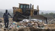 A police officer stands next to boxes of expired AstraZeneca coronavirus disease (COVID-19) vaccines at the Gosa dump site in Abuja, Nigeria December 22, 2021. REUTERS/Afolabi Sotunde
