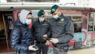 Guardia di Finanza officers check the coronavirus disease (COVID-19) health pass, known as a Green Pass, of a person at a train station the day the government restricts access of unvaccinated, in Naples, Italy December 6, 2021. REUTERS/Ciro de Luca/File Photo