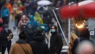 People wearing protective face masks are pictured on a rainy winter day in the Montorgueil street, amid the spread of the coronavirus disease (COVID-19) pandemic, in Paris, France, December 27, 2021. REUTERS/Christian Hartmann
