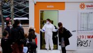 A health worker talks to people while they wait to do tests for the coronavirus disease (COVID-19) on the day before Christmas eve in Campo Pequeno, Lisbon, Portugal, December 23, 2021. REUTERS/Pedro Nunes/File Photo
