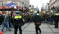 Police officers stand guard as opponents of restrictions imposed in the Netherlands to contain the spread of the coronavirus disease (COVID-19) protest despite a ban by local authorities, in Amsterdam, Netherlands, January 2, 2022. REUTERS/Piroschka van de Wouw
