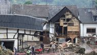 Residents remove rubble among the debris left over by the July 2021 extreme weather and lethal floods of the nearby Ahr river, in Schuld, Germany, July 17, 2021. REUTERS/Wolfgang Rattay/File Photo
