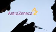 People pose with a needle in front of displayed AstraZeneca logo in this illustration taken December 11, 2021. REUTERS/Dado Ruvic/Illustration/File Photo