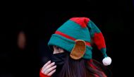  A woman dressed as an elf wears a face mask while handing out promotional leaflets in the street after mandatory mask wearing in indoor and outdoor spaces came into force because of the continuing coronavirus disease (COVID-19) pandemic, in Valletta, Malta December 11, 2021. REUTERS/Darrin Zammit Lupi/File Photo