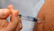 A doctor vaccinates a patient as part of the start of the seasonal influenza vaccination campaign in Gouzeaucourt, France, October 13, 2020. REUTERS/Pascal Rossignol/File Photo
