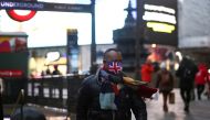 FILE PHOTO: A person wearing a protective face mask walks through Piccadilly Circus, amid the coronavirus disease (COVID-19) outbreak, in central London, Britain, January 6, 2022. REUTERS/Henry Nicholls