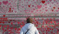 File photo: A woman views the National Covid Memorial Wall, a dedication of thousands of hand-painted hearts and messages for those in the UK who have died from COVID-19, in London, Britain, January 9, 2022. Reuters/Toby Melville/File Photo