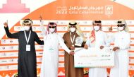 A winner of camel racing contest being given a cheque.
