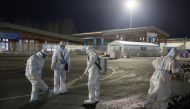 Staff wearing PPE sprays disinfectant ahead of the Beijing 2022 Winter Olympics in Zhangjiakou, China. February 1, 2022. REUTERS/Wolfgang Rattay