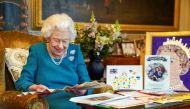Britain's Queen Elizabeth looks at a fan as she views a display of memorabilia from her Golden and Platinum Jubilees in the Oak Room at Windsor Castle, Windsor, Britain, in this undated picture issued on February 4, 2022. Steve Parsons/Pool via REUTERS