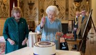 Britain's Queen Elizabeth II cuts a cake to celebrate the start of the Platinum Jubilee during a reception in the Ballroom of Sandringham House, which is the Queen's Norfolk residence, in Sandringham, Britain February 5, 2022. Joe Giddens/Pool via Reuters