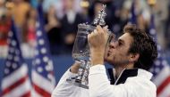Juan Martin del Potro of Argentina kisses the champions trophy after defeating Roger Federer of Switzerland in the men's final at the U.S. Open tennis championship in New York, September 14, 2009. REUTERS/David Gray (UNITED STATES SPORT TENNIS)/File Photo