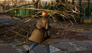 A woman walks past a fallen tree on a side street in Fulham during Storm Eunice, in London, Britain, February 18, 2022. REUTERS/Kevin Coombs