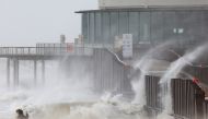People take pictures as waves break on the beach in the wake of Storm Eunice in Blankenberge, Belgium, February 18, 2022. REUTERS/Yves Herman